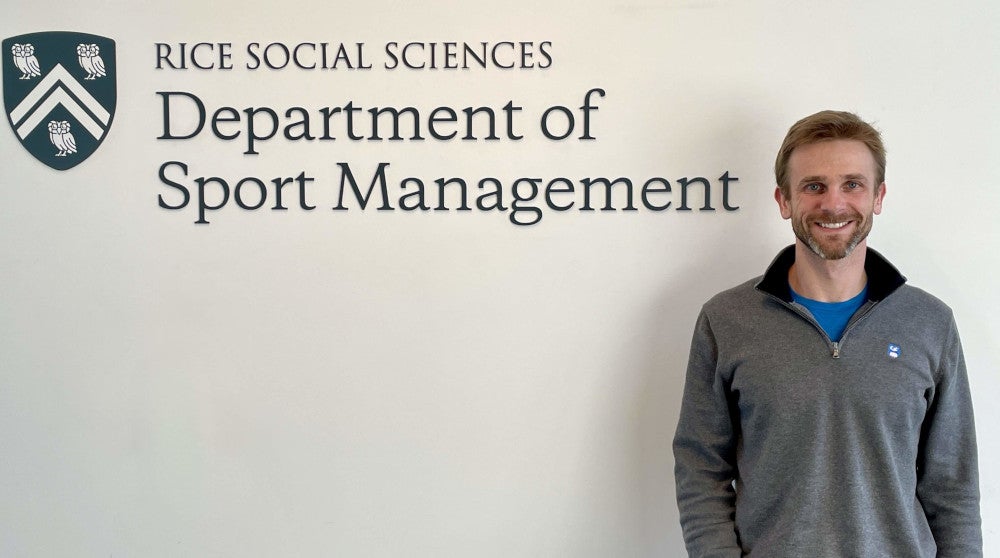 Scott Powers in front of Sport Management sign